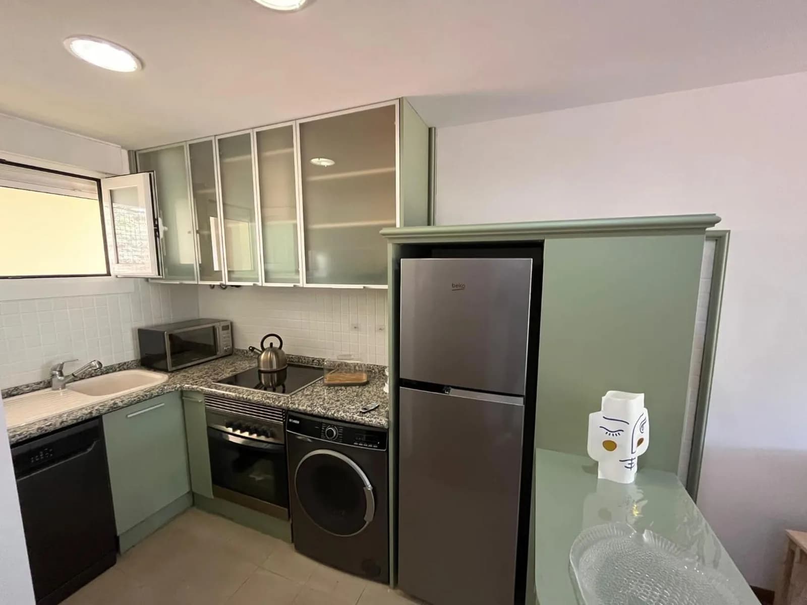 Cocina equipada del apartamento con frigorífico y zona de fregadero