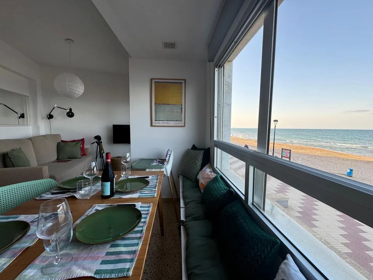 Salón del apartamento con gran ventanal y vistas frontales al mar
