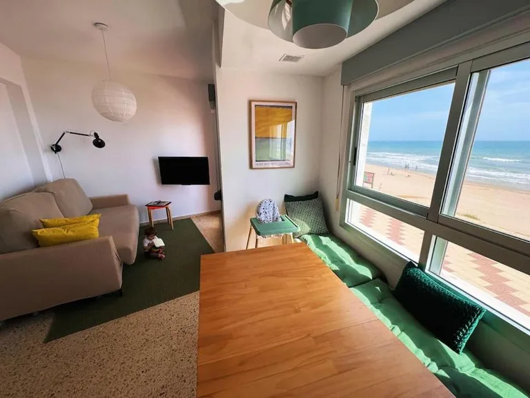 Salón luminoso del apartamento, con sofá y ventanal orientado a la playa