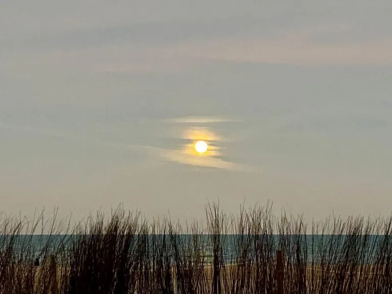 Sol entre nubes sobre las dunas de la playa de la Llastra, en la costa sur de Valencia entre El Perelló y Cullera